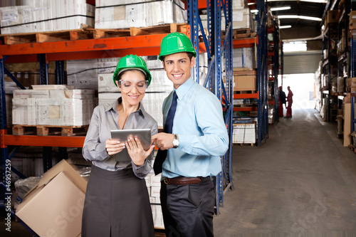 Photo: Male Supervisor Using Digital Tablet With Colleague Male Supervisor Using Digital Tablet With Colleague