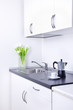 Percolator and cup of coffee on worktop, kitchen interior