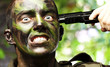 portrait of young soldier comiting suicide against a nature back