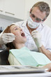 A male dentist examining a female patient