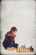 Kid (6 year old) playing chess, isolated on grunge background 