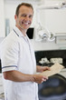 A male dentist holding patient dental records