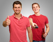 Happy Young Man Gesturing Infront Of Man Enjoying Television