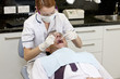 A female dentist examining a male patients teeth