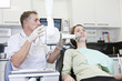 A male dentist taking an x-ray of a female patients teeth