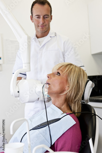 Photo: A female patient having an x-ray at the dentist A female patient having an x-ray at the dentist