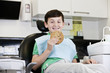 A young boy at the dentist holding a giant cookie