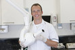 A male dentist holding an x-ray machine