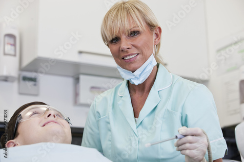 Photo: A female dental nurse/hygienist with a young boy patient A female dental nurse/hygienist with a young boy patient