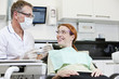 A male dentist talking to a female patient
