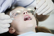 A young girl having her teeth examined by a dentist, close up