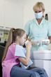 Foto: A young girl at the dentist rinsing her mouth A young girl at the dentist rinsing her mouth