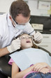A male dentist examining a young girls teeth