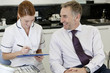 A female dentist discussing dental records with a male patient