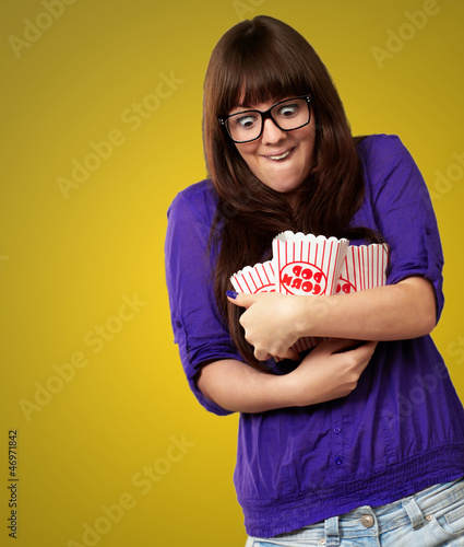Photo: Portrait Of Young Woman Holding Popcorn Container Portrait Of Young Woman Holding Popcorn Container
