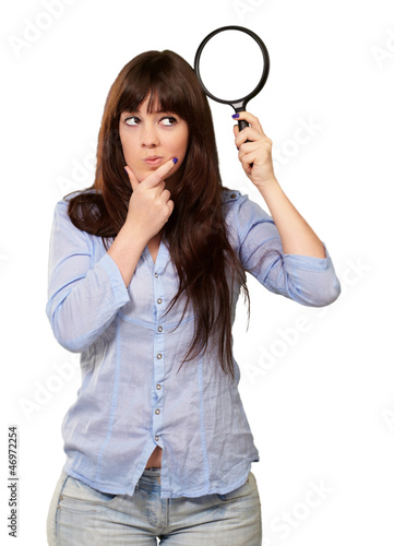 Photo: Portrait Of A Girl Holding A Magnifying Glass And Thinking Portrait Of A Girl Holding A Magnifying Glass And Thinking