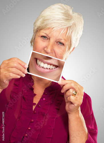 Photo: Senior Woman With Manifying Glass Showing Teeth Senior Woman With Manifying Glass Showing Teeth
