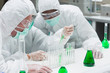 Two chemists experimenting with the green liquid
