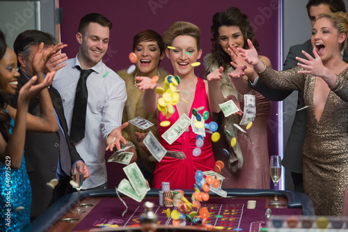 Photo: People throwing chips and cash on roulette table People throwing chips and cash on roulette table
