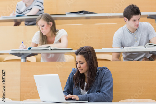 Photo: Students in a lecture with one using laptop Students in a lecture with one using laptop