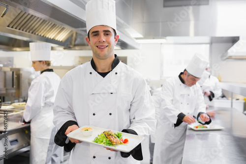 Photo: Happy chef holding salmon dish Happy chef holding salmon dish