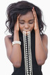 Photo: Woman standing with necklace in her mouth Woman standing with necklace in her mouth