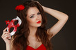 Beautiful Woman with red lips holding Carnival mask in hand.