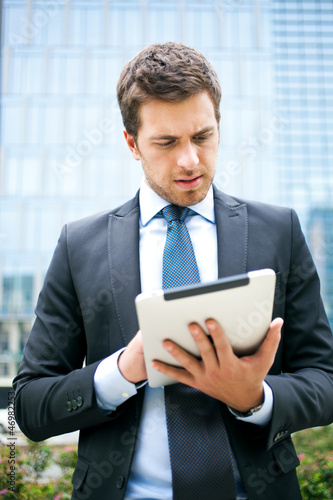 Photo: Businessman using a tablet outdoor Businessman using a tablet outdoor