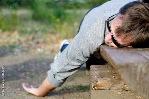 Photo: Exhausted man sleeping it off on a bench Exhausted man sleeping it off on a bench