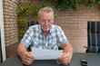 Senior smiling and reading a document
