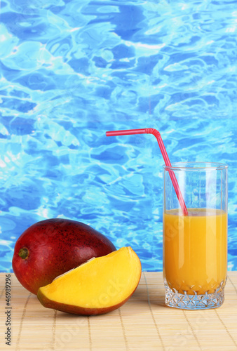 Photo: Ripe appetizing mango on woven napkin on water background Ripe appetizing mango on woven napkin on water background