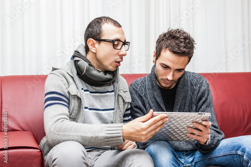 Photo: Two Youn Men Playing with Tablet PC Two Youn Men Playing with Tablet PC