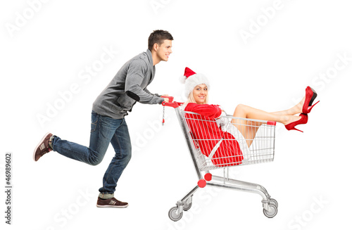 Photo: Guy pushing a woman wearing christmas costume in a shopping cart Guy pushing a woman wearing christmas costume in a shopping cart