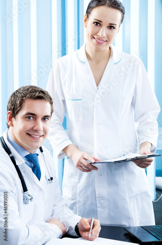 Photo: Two happy medical people working at office Two happy medical people working at office