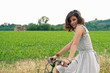 Photo: Beautiful young woman portrait with bike in a country road. Beautiful young woman portrait with bike in a country road.