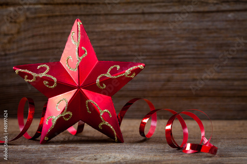 Photo: red star , gifts and ribbons on weathered wooden board red star , gifts and ribbons on weathered wooden board