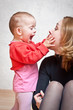 Mother playing with baby daughter