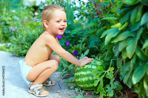 Photo: happy baby boy with big watermelon in summer garden happy baby boy with big watermelon in summer garden