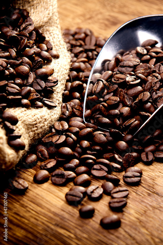 Photo: Kaffeetasse und geröstete Bohnen auf Holztisch - Kaffeegenuss Kaffeetasse und geröstete Bohnen auf Holztisch - Kaffeegenuss