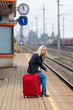 Frau wartet auf Bahnhof auf ihren Zug