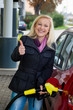 Frau beim tanken auf Tankstelle