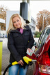 Frau beim tanken auf Tankstelle