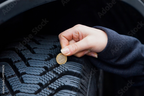 Photo: Frau misst Reifenprofil eines Autoreifen Frau misst Reifenprofil eines Autoreifen