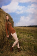 Beautiful woman near a haystack