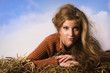 Pretty girl resting on straw bale