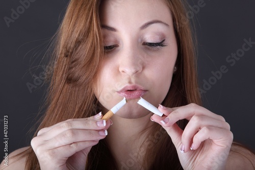 Photo: woman and stop smoking cigarette (focus on cigarette) woman and stop smoking cigarette (focus on cigarette)