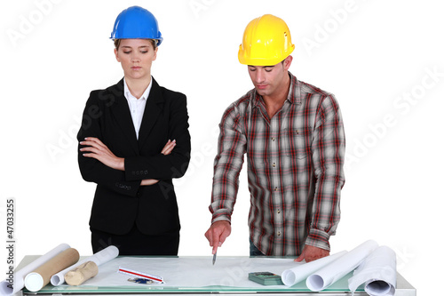 Photo: Tradesman pointing out an error to an engineer Tradesman pointing out an error to an engineer