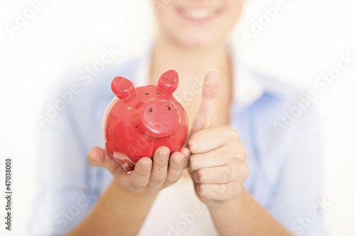 Photo: Junge Frau mit rotem Sparschwein Junge Frau mit rotem Sparschwein