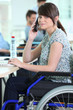 Young woman in a wheelchair at her desk