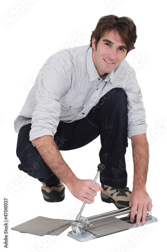 Photo: Man with a tile cutter Man with a tile cutter